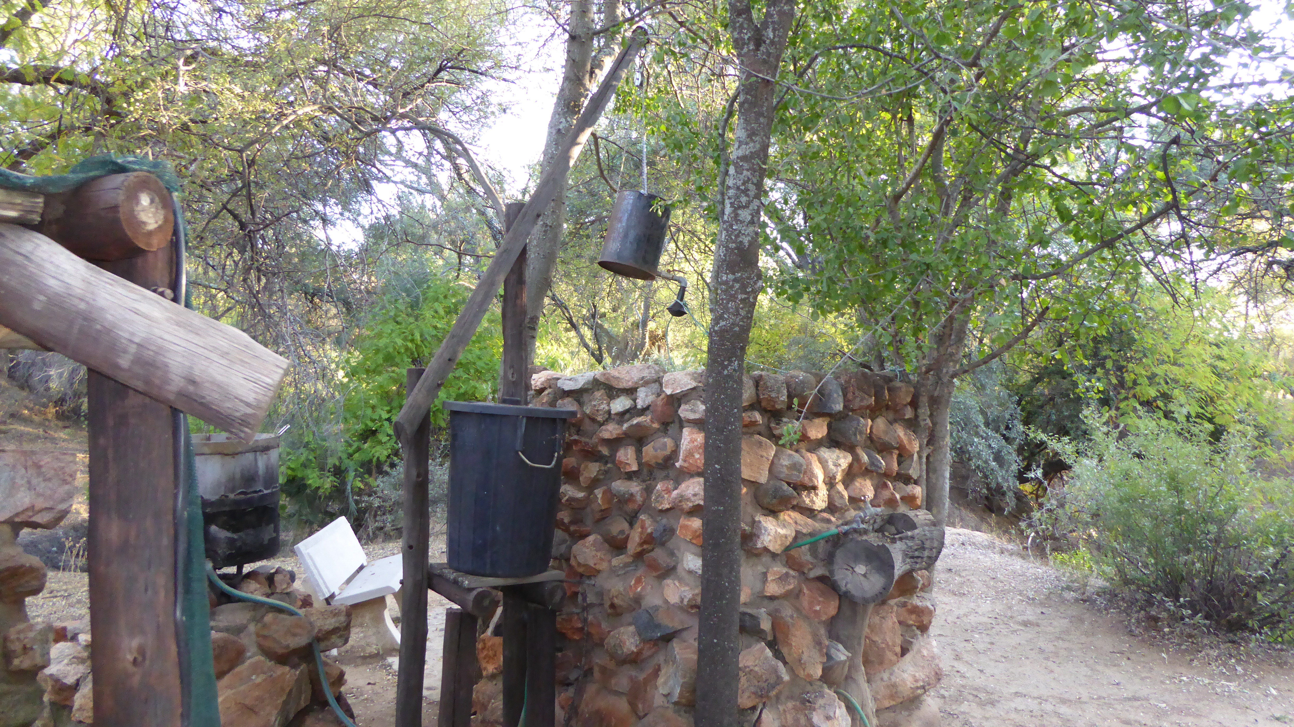 Bush camp shower! large pot you pump water into, and light a fire under. As the water heats it rises up the hose and into the container over your head. Pretty clever!
